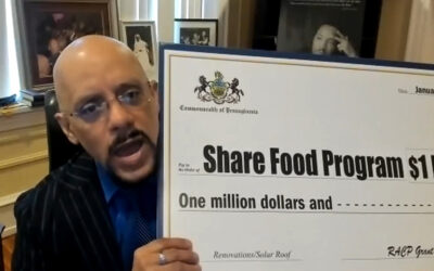 El senador Hughes entrega un cheque simulado de 1 millón de dólares al Programa Share Food para mejoras en el tejado y nuevos paneles solares